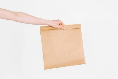 Kurye, izole edilmiş beyaz arka planda içinde yiyecek olan bir kese kağıdı tutuyor. Hızlı ve ücretsiz teslimat. Çevrimiçi mağazalar ve Express dağıtımı