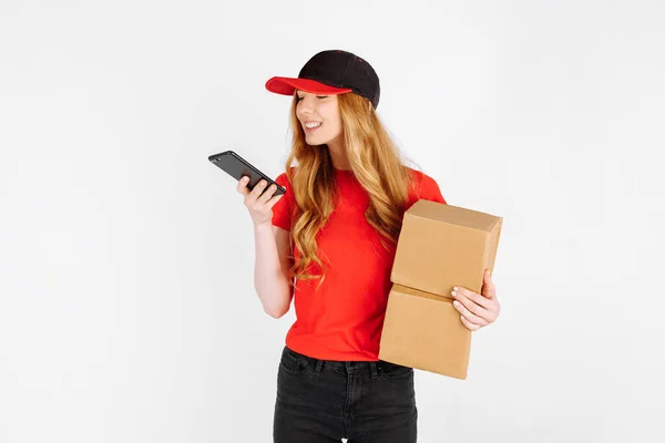 Kurýrní Dívka Uniformě Drží Kartónové Krabice Mluví Mobilním Telefonu Bílém — Stock fotografie
