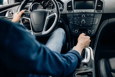 Araba kullanırken direksiyonu tutan bir adamın yakın çekimi.
