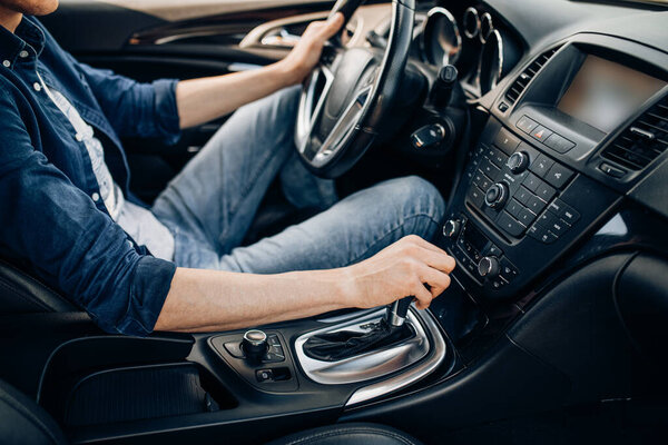 Крупный план мужчины, держащего руль во время вождения автомобиля
