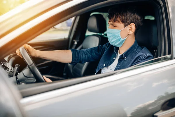 Jovem Dirigindo Carro Uma Máscara Médica Durante Uma Epidemia Motorista — Fotografia de Stock