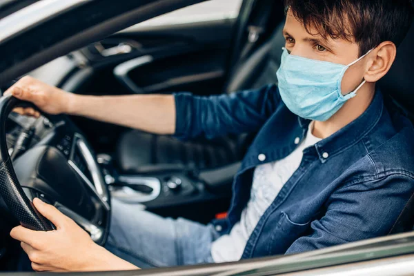 Jovem Dirigindo Carro Uma Máscara Médica Durante Uma Epidemia Motorista — Fotografia de Stock