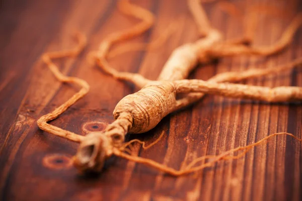 Ginseng seco em um fundo de madeira — Fotografia de Stock