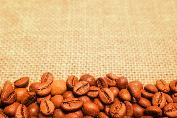 Coffee beans on burlap background — Stock Photo, Image