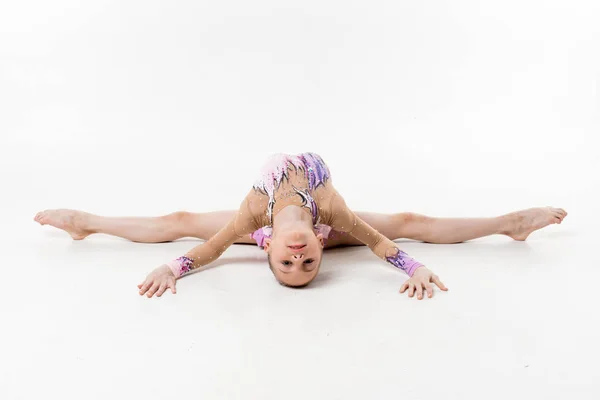 Bir genç Genç kız tek parça streç giysi şovları jimnastik ve beyaz bir arka plan üzerinde bale egzersizleri.