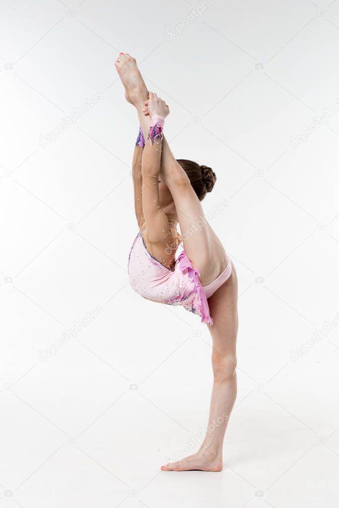 A young teenage girl in leotard shows gymnastic and ballet exercises on a white background.