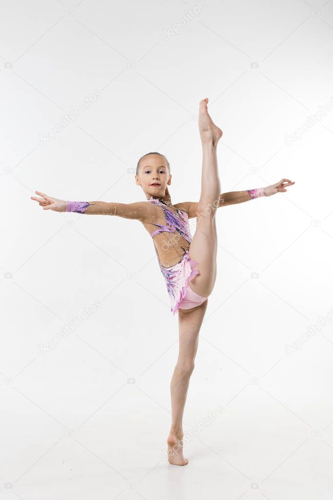 A young teenage girl in leotard shows gymnastic and ballet exercises on a white background.