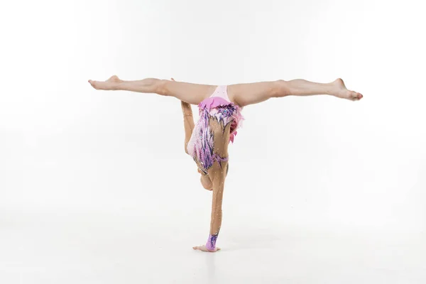 一个穿着紧身衣的年轻女孩在白色的背景上展示体操和芭蕾练习 — 图库照片