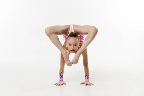 Bir genç Genç kız tek parça streç giysi şovları jimnastik ve beyaz bir arka plan üzerinde bale egzersizleri.