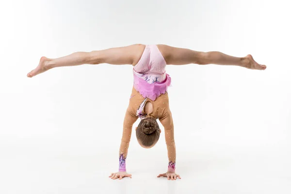Bir genç Genç kız tek parça streç giysi şovları jimnastik ve beyaz bir arka plan üzerinde bale egzersizleri.