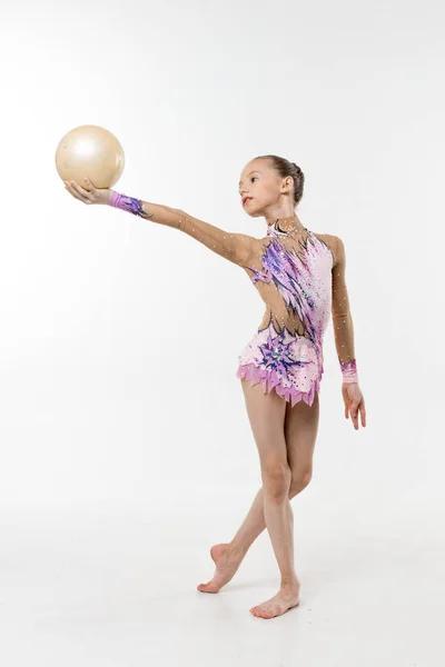 Bir genç Genç kız tek parça streç giysi şovları jimnastik ve beyaz bir arka plan üzerinde bale egzersizleri.