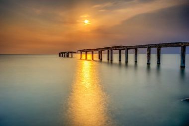 Bir uzun pozlama fotoğraf, terk edilmiş eski iskelesi ile bulutlu befor