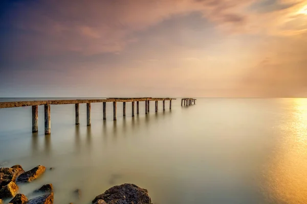 Una larga exposición foto de viejo embarcadero abandonado con befor nublado — Foto de Stock