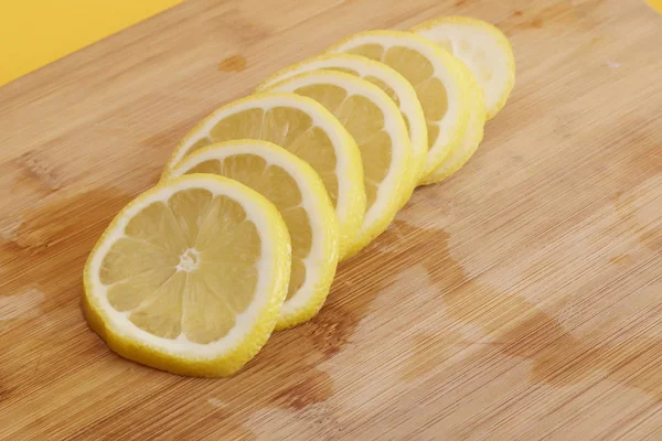 Sliced lemon at cutting board isolated on color background — Stock Photo, Image