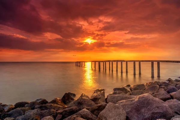 Um longo quadro de exposição de velho molhe abandonado com sol ardente — Fotografia de Stock