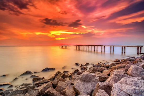 Um longo quadro de exposição de velho molhe abandonado com sol ardente — Fotografia de Stock