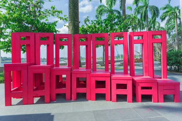 Concept of ecological tourism. The red wooden chairs at the park