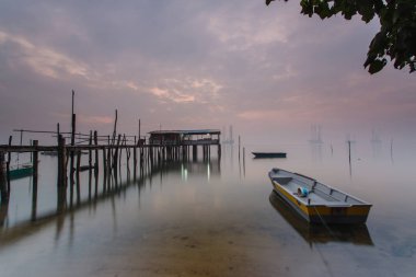 Bulutlu uzun pozlama gündoğumu iskeleye vurmuş. Görüntü içeren certai