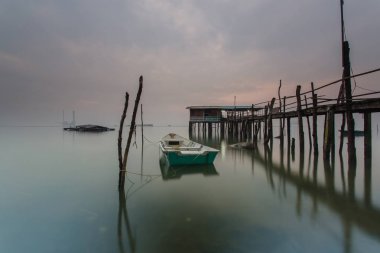 Bulutlu uzun pozlama gündoğumu iskeleye vurmuş. Görüntü içeren certai