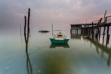 Bulutlu uzun pozlama gündoğumu iskeleye vurmuş. Görüntü içeren certai