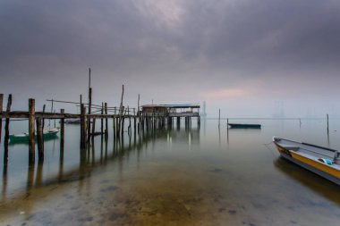 Bulutlu uzun pozlama gündoğumu iskeleye vurmuş. Görüntü içeren certai