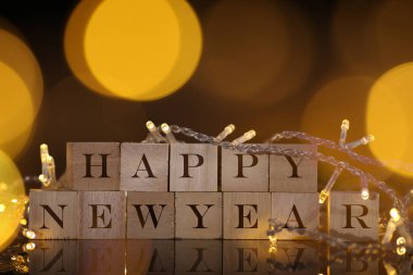 Mutlu yeni yıl geri ahşap blok ışık ve bokeh ile yazılı