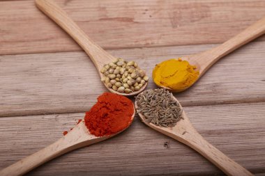 Çeşitli otlar ve baharatlar tahta kaşıklar içinde. Baharat düz lay