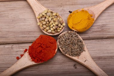 Çeşitli otlar ve baharatlar tahta kaşıklar içinde. Baharat düz lay