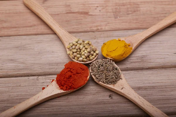 Çeşitli otlar ve baharatlar tahta kaşıklar içinde. Baharat düz lay