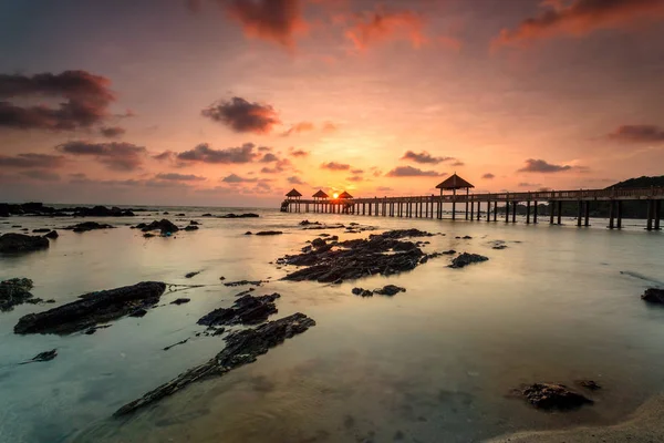 Una imagen de larga exposición del amanecer dorado con embarcadero de piedra — Foto de Stock