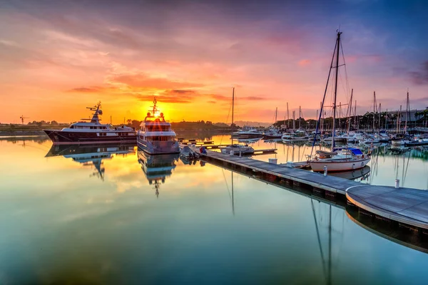 A majestic sunrise with boat resting near   the dock as foregrou — Stock Photo, Image