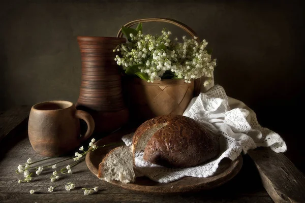 Кувшин с кружкой и домашним хлебом — стоковое фото