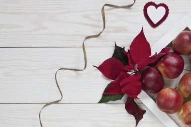 Kırmızı elma, Atatürk çiçeği ve Noel baharat beyaz ahşap arka planda, üstten görünüm