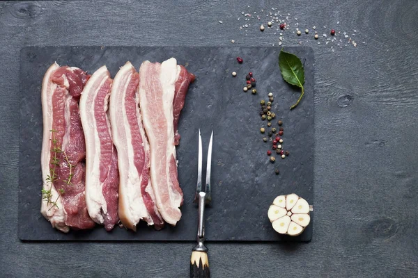 Close Van Plakjes Spek Met Kruiden Stenen Bord Grijze Tafel — Stockfoto