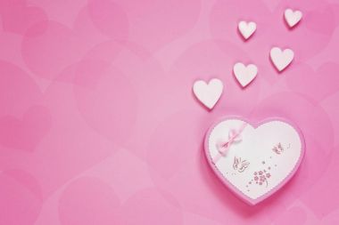 Hediyelik kutu pembe kağıt arka plan üzerinde bir kalp şeklinde. Valentine's Day, düğün, nişan ve diğer romantik olayları için kavram. Üstten Görünüm, yakın çekim