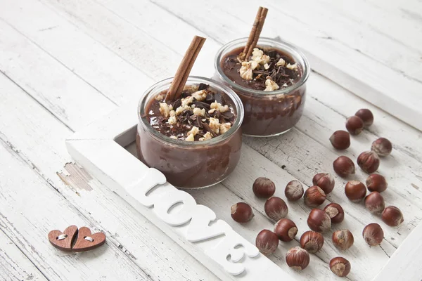 Chocolate yogurt on the table. Family breakfast, healthy food. Selective focus, close-up, shallow depth of field. Vintage white wooden background