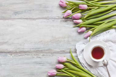 güzel Pembe Lale çiçek yakın ahşap masa arka plan üzerinde çay ile çekim