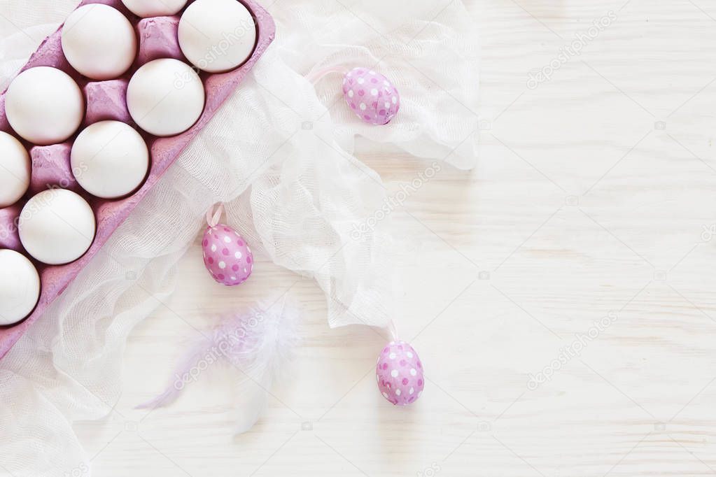 Close-up of white Easter eggs in pink paper box with white scarf on wooden table background