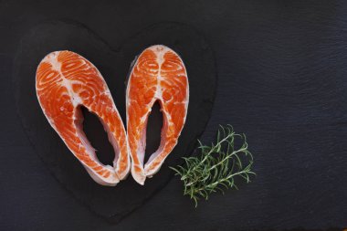 Biberiye yaprağı üzerinde siyah tablo arka plan ile taze somon balık yakın çekim fotoğraf