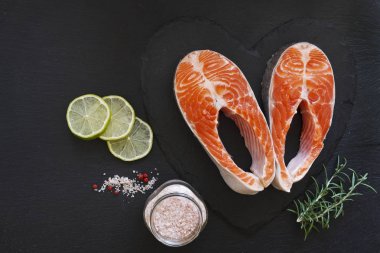 taze somon balık siyah tablo arka plan üzerinde deniz tuz ve limon dilimleri ile yakın çekim fotoğraf