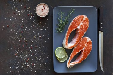 taze somon balık siyah tablo arka plan üzerinde deniz tuz ve limon dilimleri ile yakın çekim fotoğraf