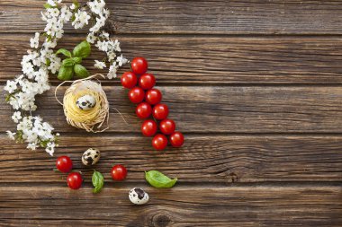 Kiraz domates, bıldırcın yumurtası ve fesleğen ile ham geleneksel İtalyan makarna close-up. Antika ahşap zemin üzerine Üstten Görünüm