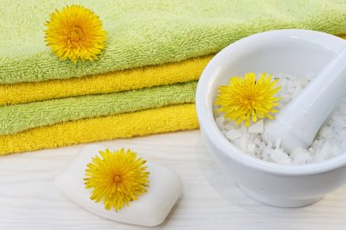 Sabunu, banyo havlusu ve deniz tuzu kase sarı güzel karahindiba çiçeklerin yakın çekim fotoğraf