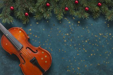 Old violin and fir-tree branches with Christmas decor wits glitt