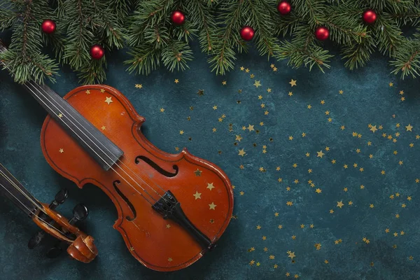 İki eski keman ve Noel desenli köknar ağacı dalları 