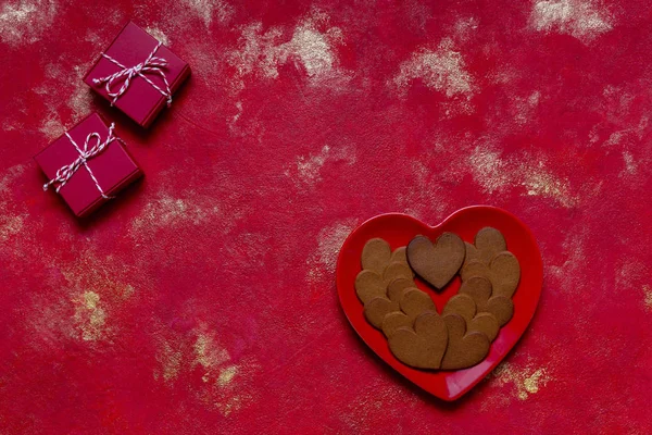 Kształt serca Pierniki na czerwonej płytce w kształcie serca i dwa prezenty — Zdjęcie stockowe