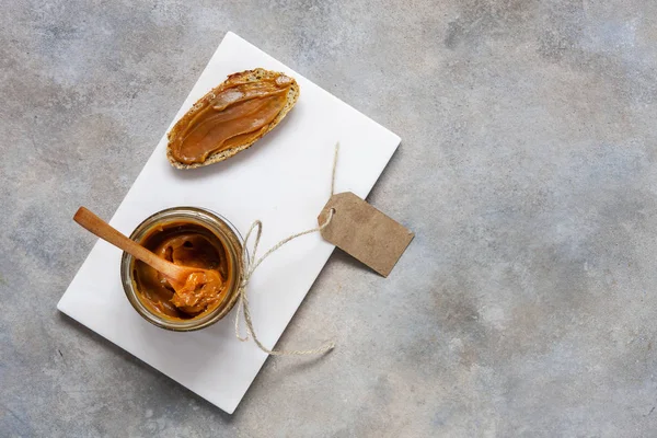 Botol kaca buatan sendiri saus karamel asin dengan dan roti — Stok Foto