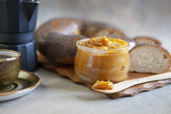 Botol kaca saus karamel asin buatan sendiri dengan roti dan kenari — Stok Foto