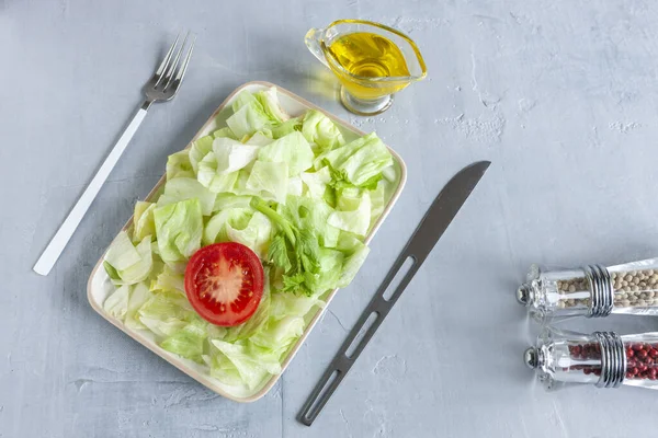 Plate with green iceberg lettuce, olive oil,tomatoe,  Intermittent fasting concept, diet, weight loss