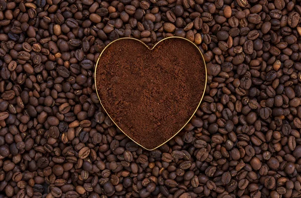 Świeża Kawa Mielona Kształcie Serca Tle Ziaren Kawy — Zdjęcie stockowe